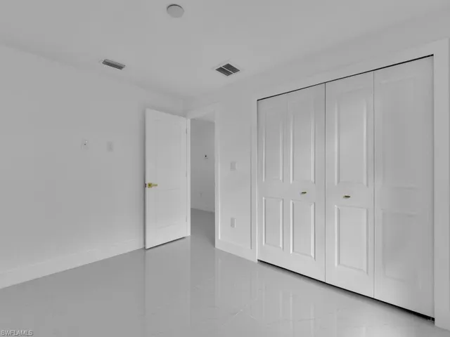 Unfurnished bedroom featuring light tile patterned flooring and a closet