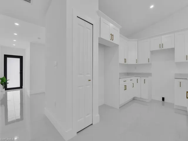 Clothes washing area featuring light tile patterned flooring