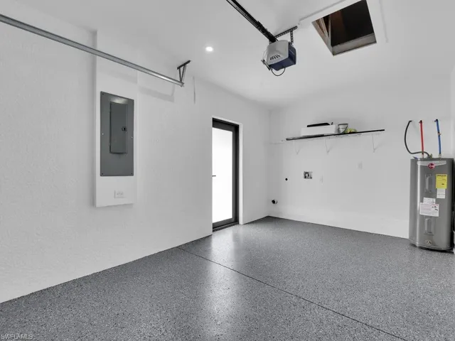 Garage with electric water heater, a garage door opener, and electric panel