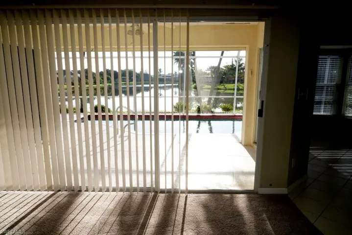 Doorway to outside featuring a water view, tile patterned flooring, and carpet floors