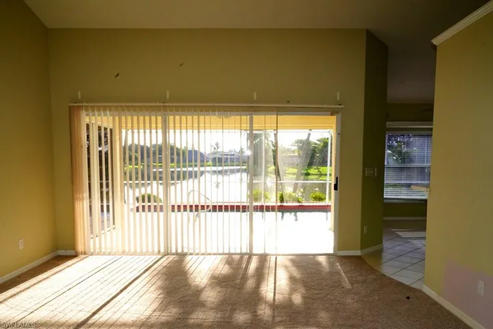 Carpeted spare room with a water view and baseboards