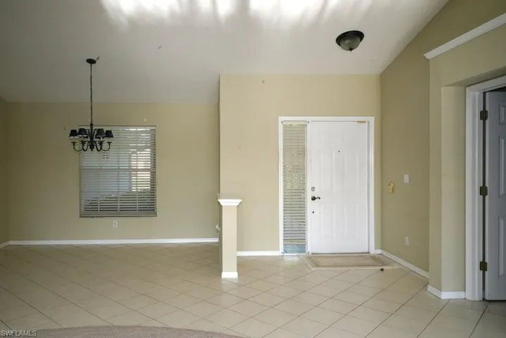 Entrance foyer featuring light tile patterned flooring and a chandelier