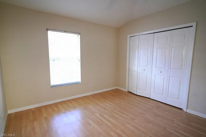 Unfurnished bedroom with light wood-type flooring, ceiling fan, and a closet