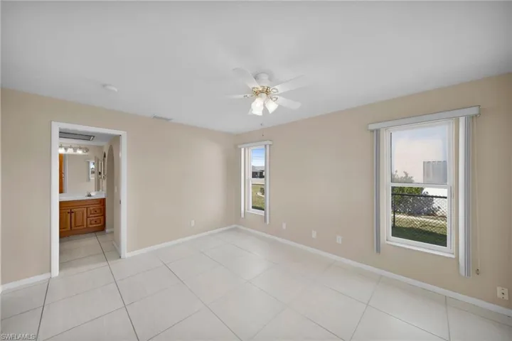 Unfurnished room with ceiling fan and light tile patterned floors