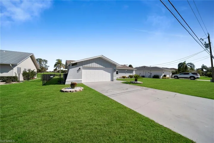 Ranch-style house with a garage and a front lawn
