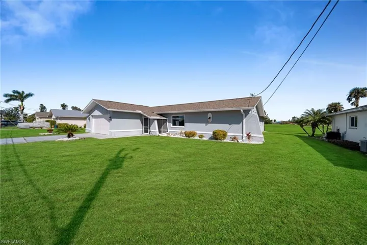 Ranch-style house with cooling unit, a garage, and a front yard