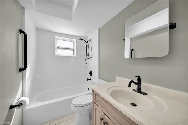Full bathroom with toilet, shower / tub combination, vanity, and tile patterned floors