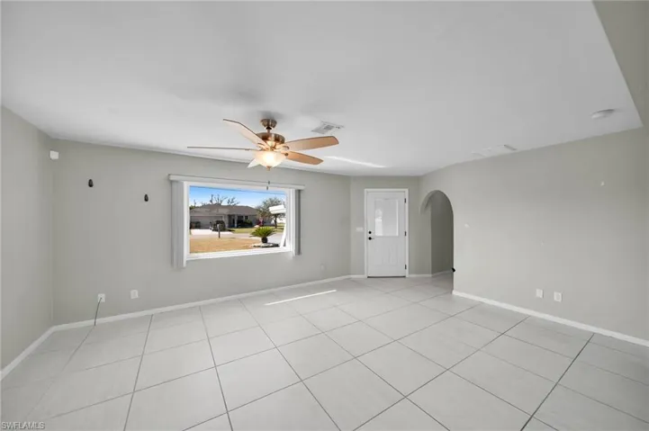 Empty room featuring light tile patterned floors and ceiling fan
