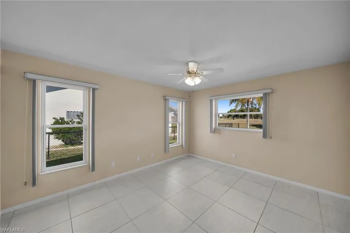 Empty room featuring ceiling fan and light tile patterned flooring
