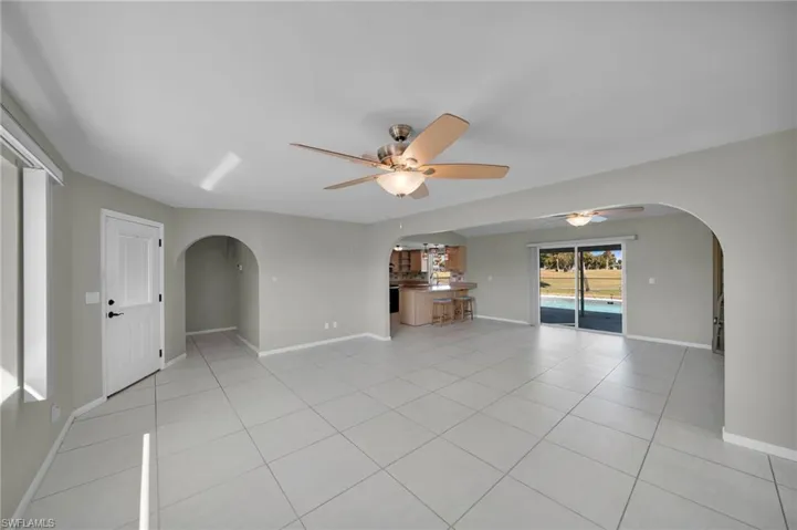 Unfurnished living room featuring light tile patterned floors and ceiling fan