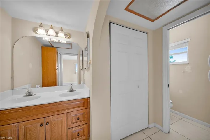 Bathroom featuring tile patterned floors, vanity, and toilet