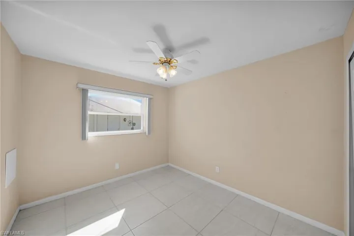 Tiled empty room featuring ceiling fan