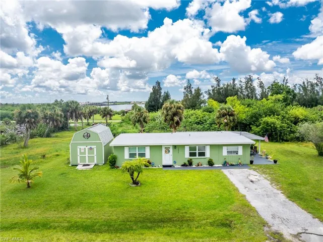 Ranch-style house featuring a storage shed and a front yard