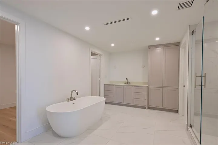 Bathroom with vanity, shower with separate bathtub, and hardwood / wood-style floors