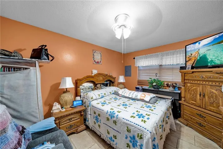 Bedroom with light tile patterned flooring and ceiling fan