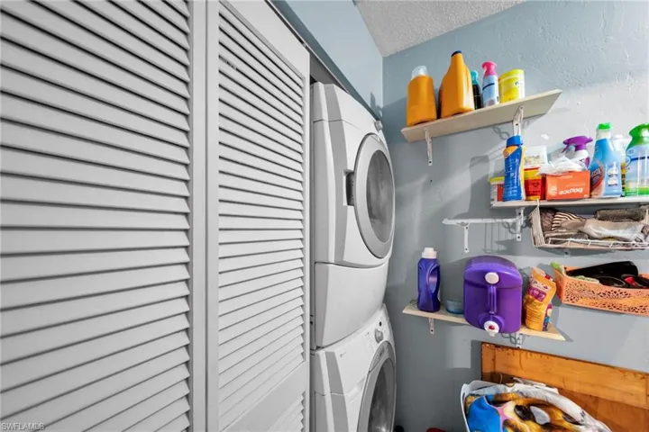 Washroom featuring estacked washer and dryer and a textured ceiling