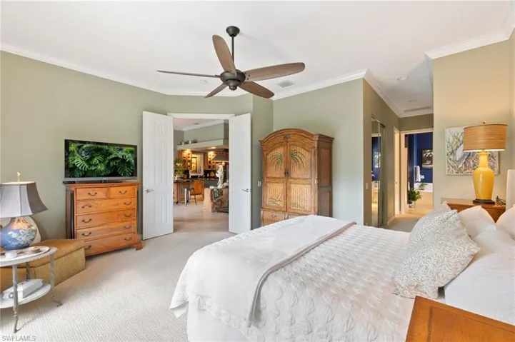Carpeted bedroom featuring crown molding and a ceiling fan