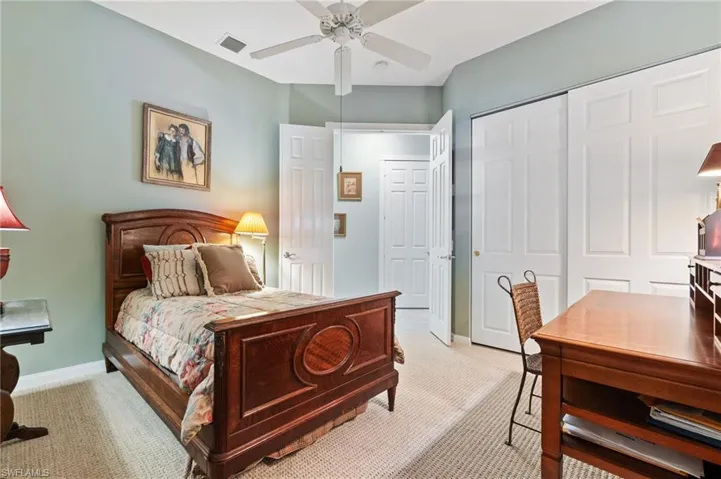 Bedroom featuring light colored carpet, ceiling fan, and a closet