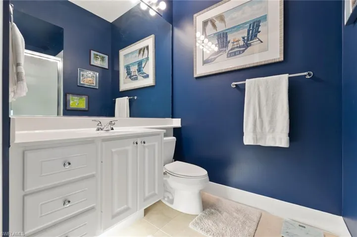 Bathroom with light tile patterned flooring, vanity, and a shower stall