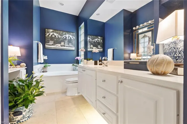 Bathroom featuring light tile patterned floors, a bath, and vanity