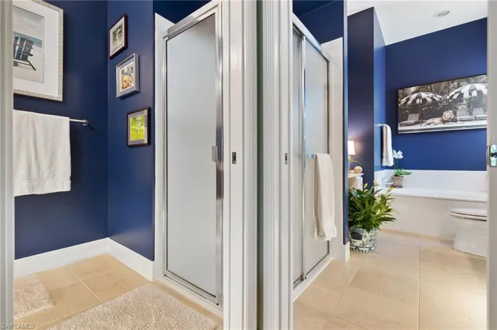 Full bath featuring light tile patterned flooring, a stall shower, and a garden tub