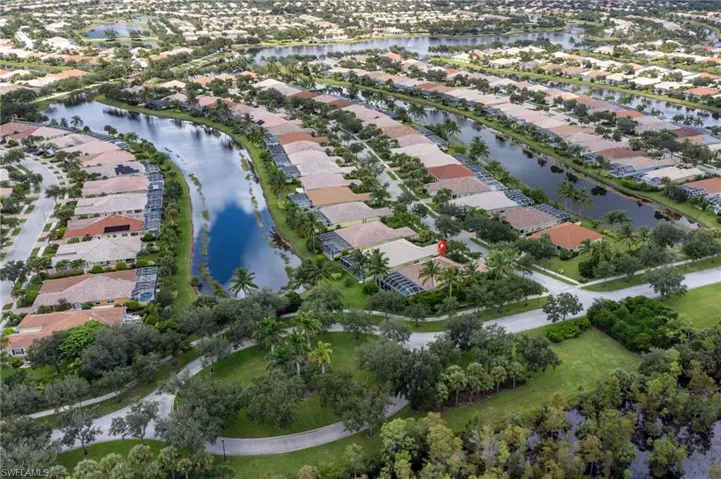 Aerial view of property and surrounding area featuring nearby suburban area and a large body of water