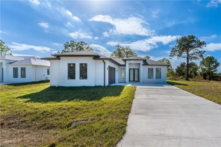View of front of property with a front lawn and a garage