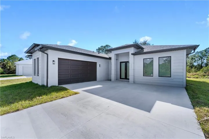 View of front of property featuring a garage and a front lawn