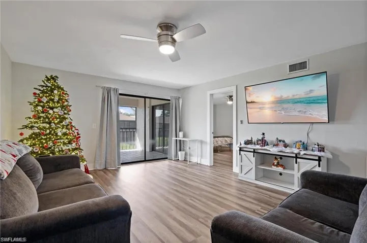 Living room with light hardwood / wood-style flooring and ceiling fan