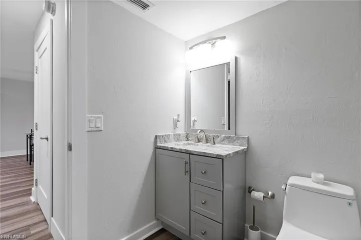 Bathroom featuring toilet, hardwood / wood-style flooring, and vanity