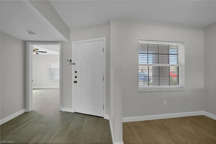 Entrance foyer with dark hardwood / wood-style floors and ceiling fan