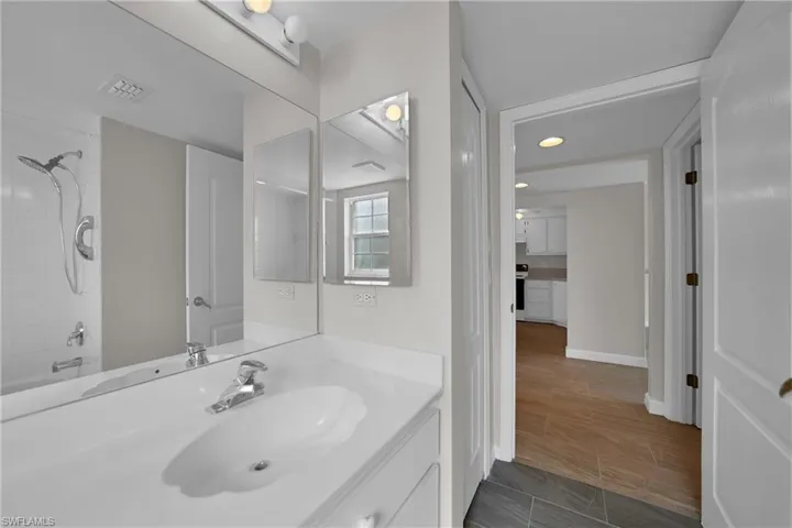 Bathroom with vanity, tiled shower / bath, and tile patterned flooring