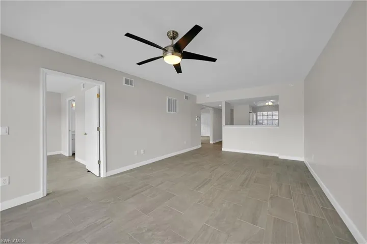 Unfurnished living room featuring light tile patterned floors and ceiling fan