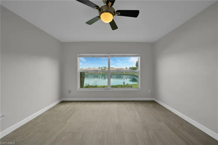 Unfurnished room featuring a water view, light wood-type flooring, and ceiling fan