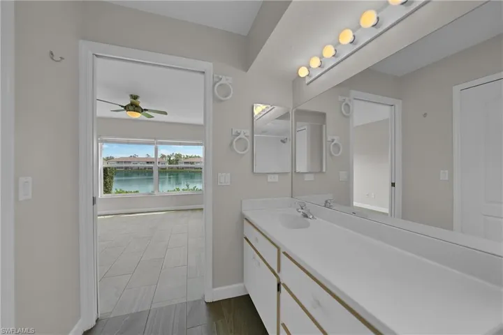 Bathroom with vanity, a water view, tile patterned flooring, and ceiling fan