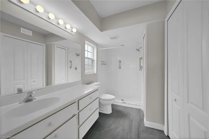 Bathroom with tile patterned floors, toilet, vanity, and a tile shower
