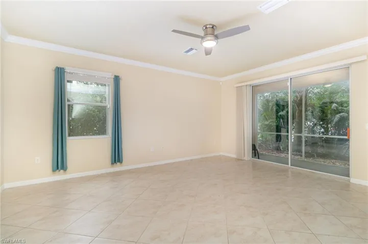 Unfurnished room with crown molding, a ceiling fan, and light tile patterned floors