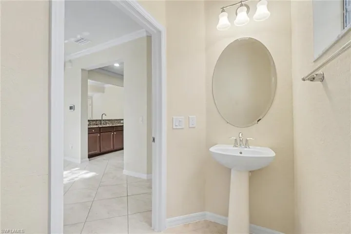 Bathroom featuring light tile patterned floors and ornamental molding