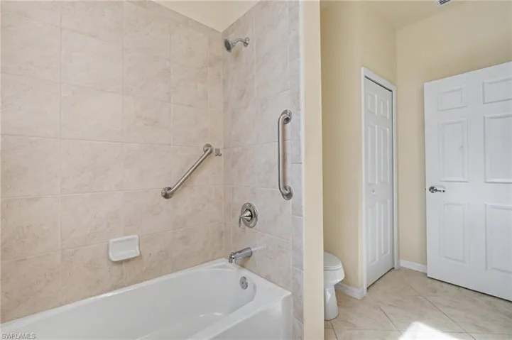 Full bath with tub / shower combination and light tile patterned flooring
