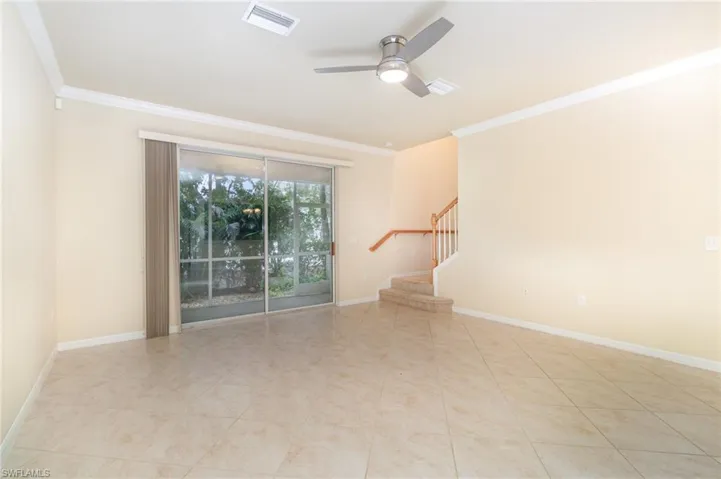 Spare room featuring stairs, ceiling fan, and ornamental molding