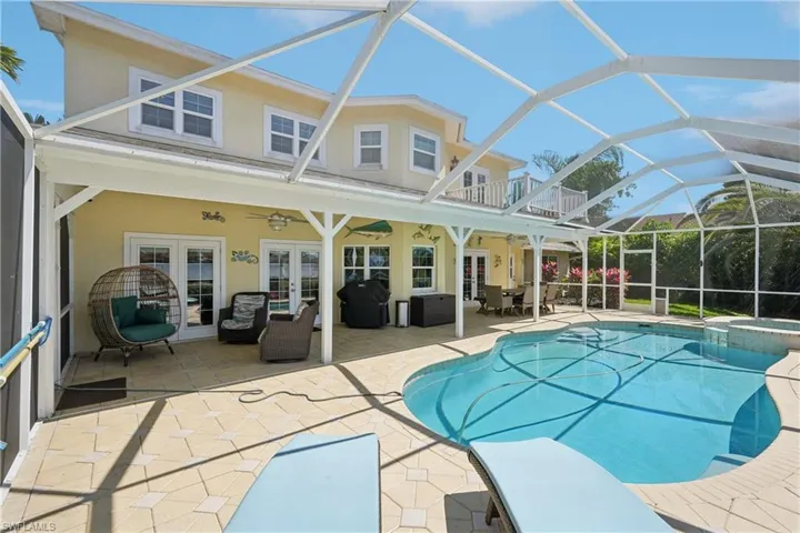 Relaxing pool / spa featuring french doors, glass enclosure, a patio area, and a sunroom