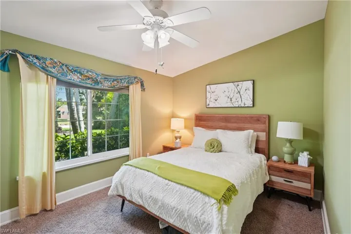Carpeted bedroom with vaulted ceiling and a ceiling fan