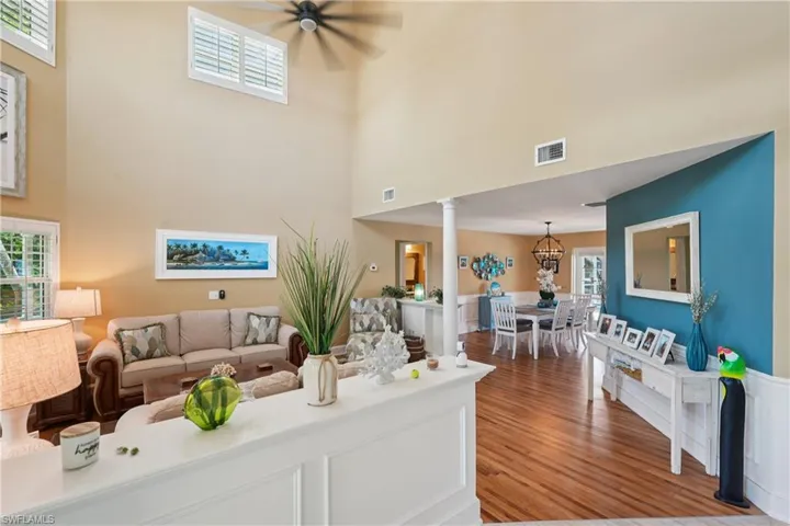 Living room featuring light wood-type flooring and a high ceiling