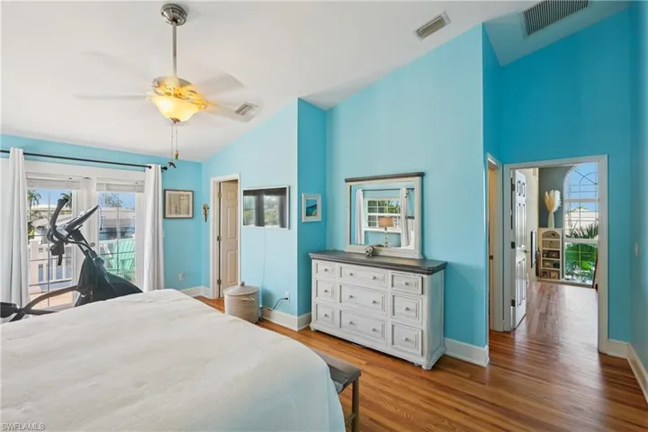 Bedroom featuring access to outside, light wood-type flooring, ceiling fan, and vaulted ceiling