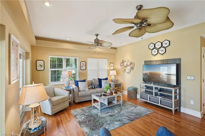 Living area featuring wood finished floors, ceiling fan, and recessed lighting