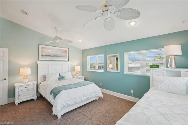 Bedroom featuring vaulted ceiling, a ceiling fan, and carpet