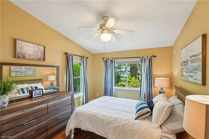Bedroom featuring vaulted ceiling, dark wood finished floors, and ceiling fan