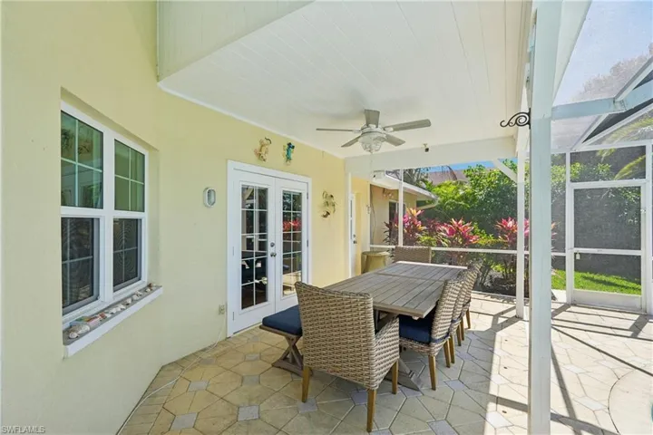 View of patio with french doors, a lanai, outdoor dining space, a sunroom, and a ceiling fan