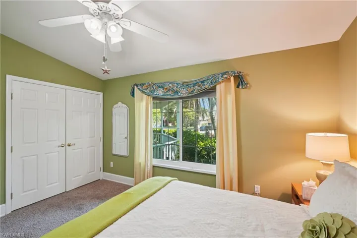 Bedroom featuring carpet flooring, ceiling fan, a closet, and vaulted ceiling