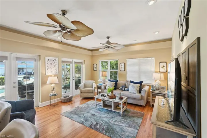 Living room with light wood-style flooring, french doors, and a ceiling fan